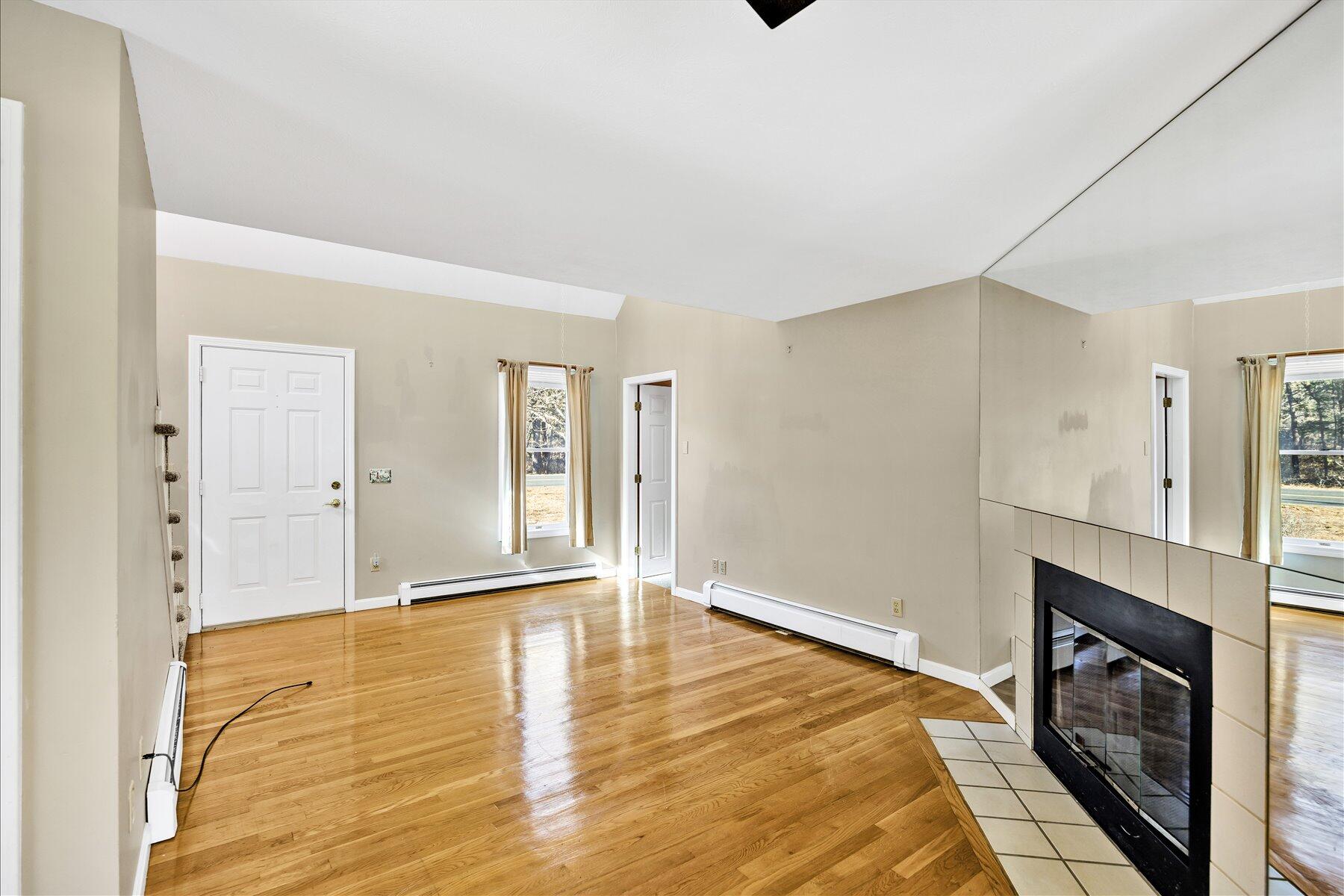 171 Currier Road East Falmouth, MA 02536 - Photo 14 of 47 a view of an empty room with wooden floor and a fireplace