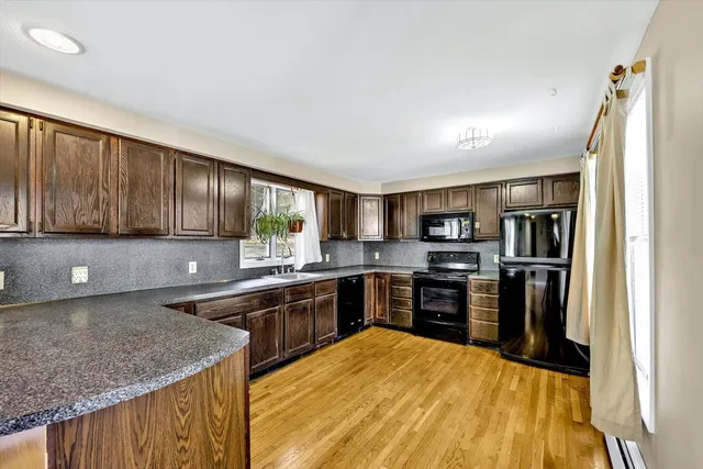 a kitchen with stainless steel appliances granite countertop lots of counter top space and wooden floor
