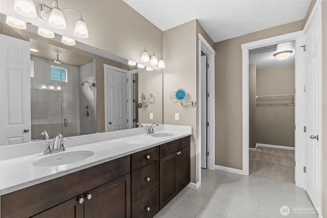 a bathroom with a double vanity sink mirror and shower