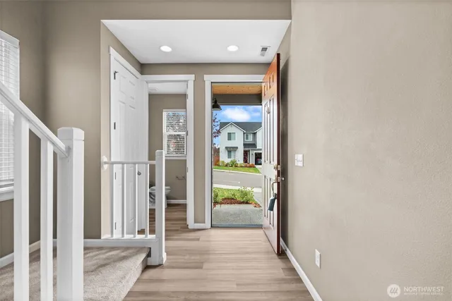 a view of a hallway with wooden floor and a living room