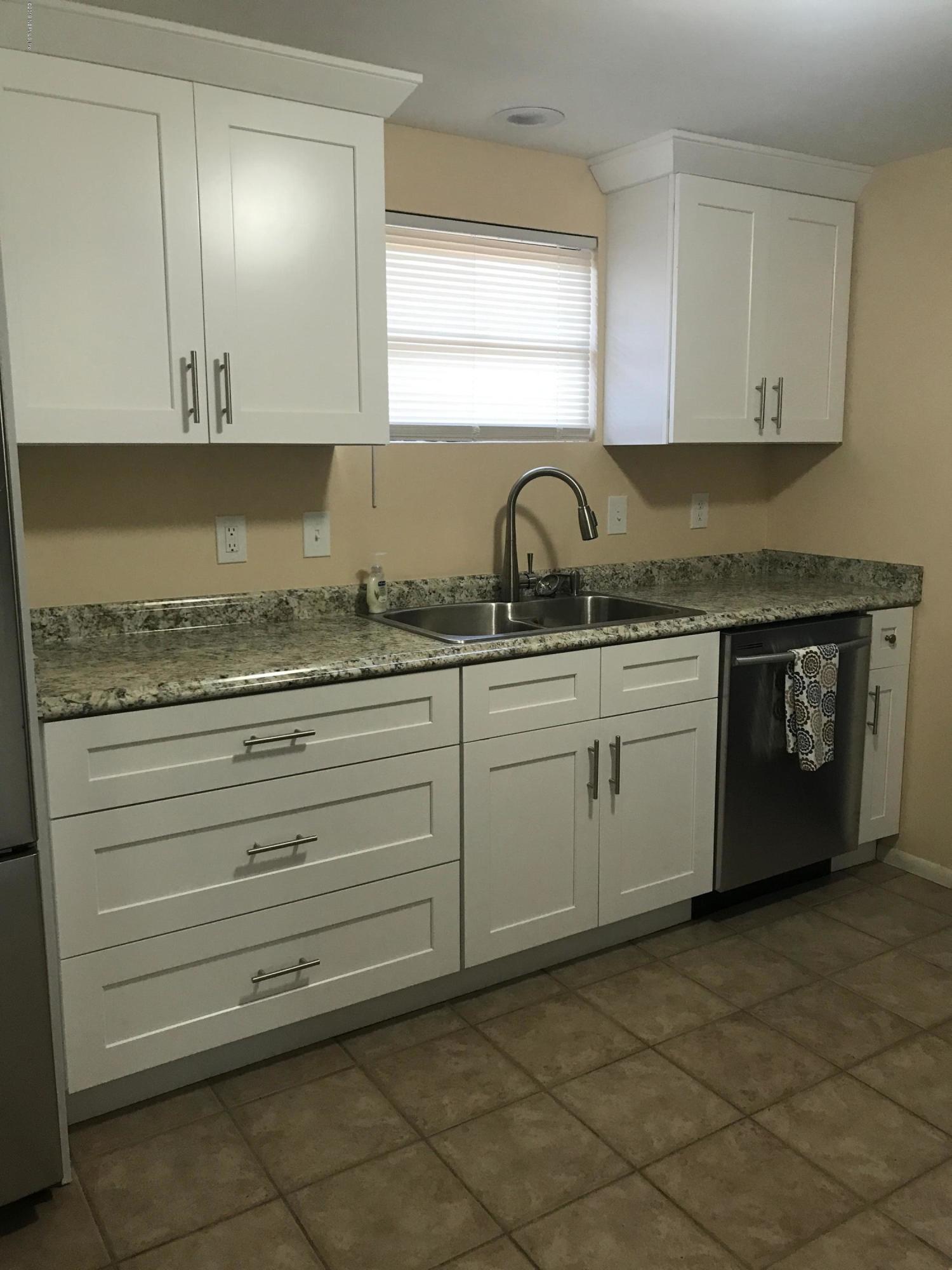5626 Ricker Road Jacksonville, FL 32244 - Photo 9 of 25 a kitchen with granite countertop white cabinets and sink