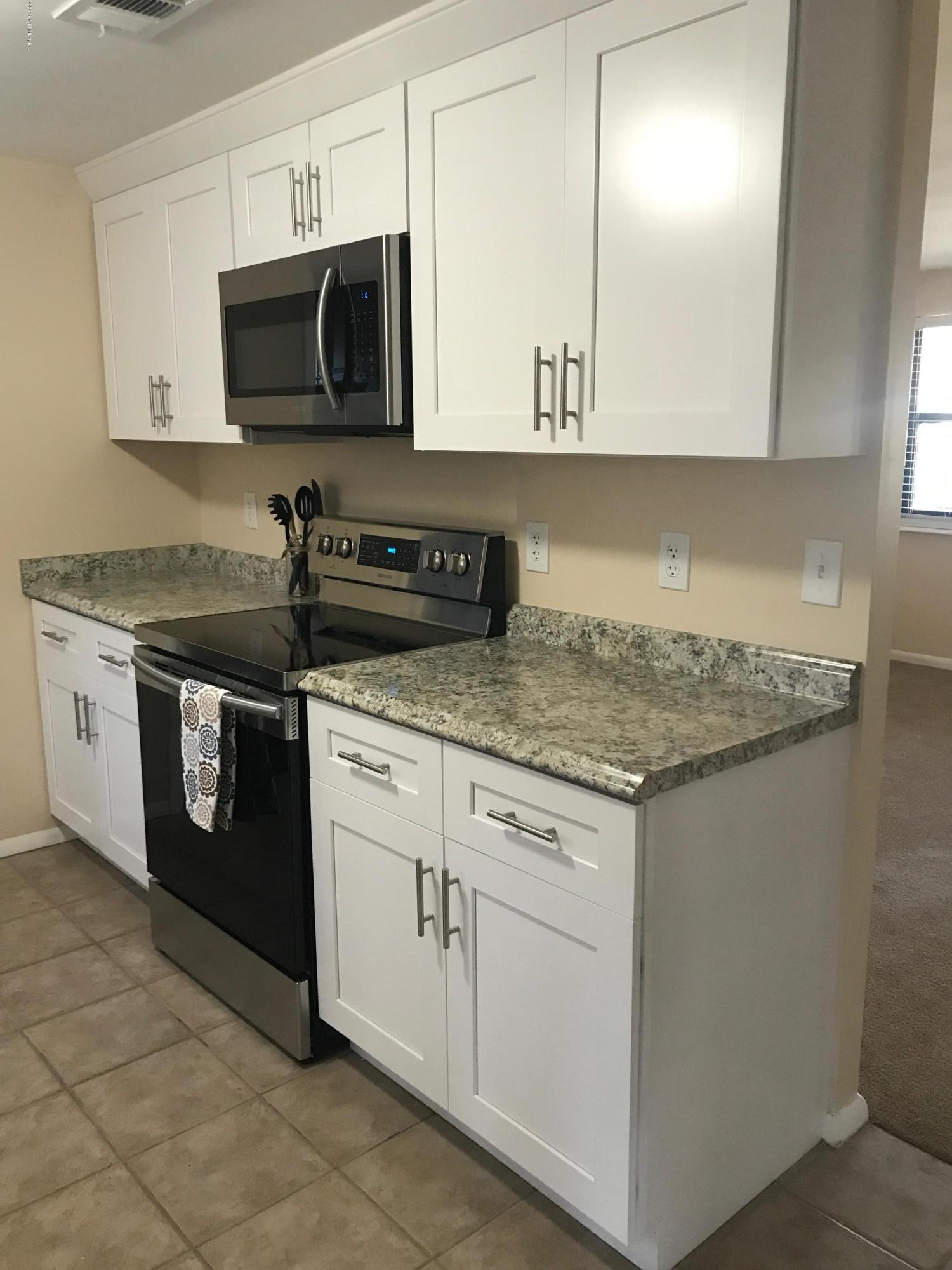 5626 Ricker Road Jacksonville, FL 32244 - Photo 10 of 25 a kitchen with stainless steel appliances granite countertop a sink and a stove