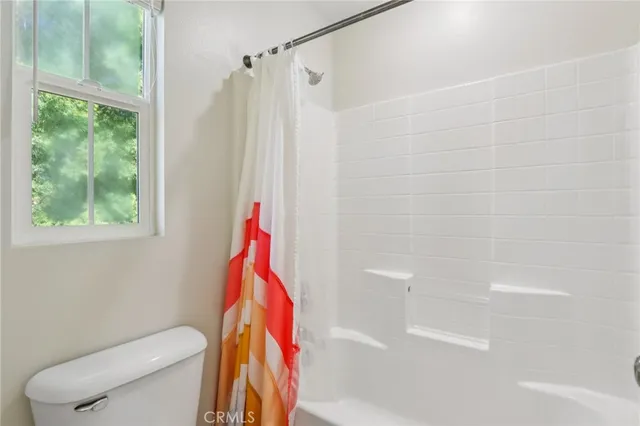 a bathroom with a toilet and a shower