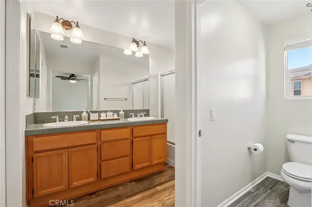 a bathroom with a granite countertop sink a toilet and a mirror