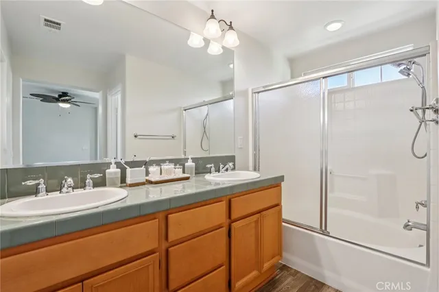 a bathroom with a double vanity sink mirror and shower