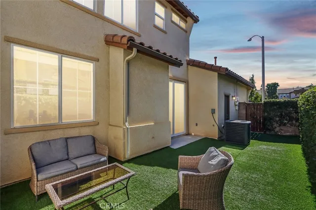 a backyard of a house with a table and chairs