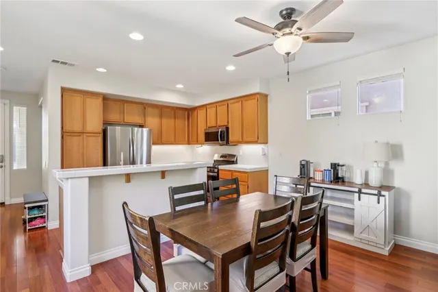 a kitchen with a dining table chairs and wooden floor