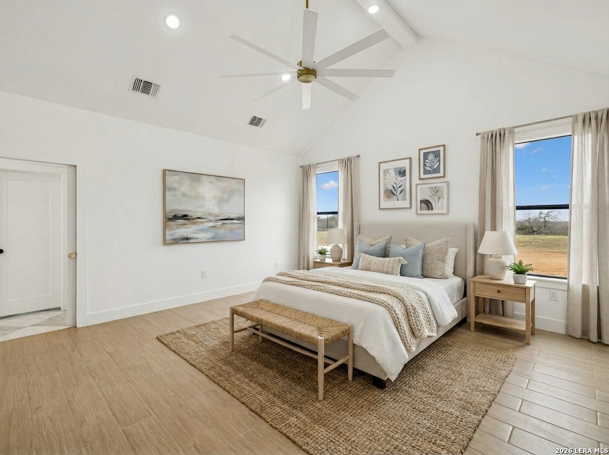 191 Hidden Ranch Court Floresville, TX 78114 - Photo 17 of 38 a bedroom with a bed and a chandelier