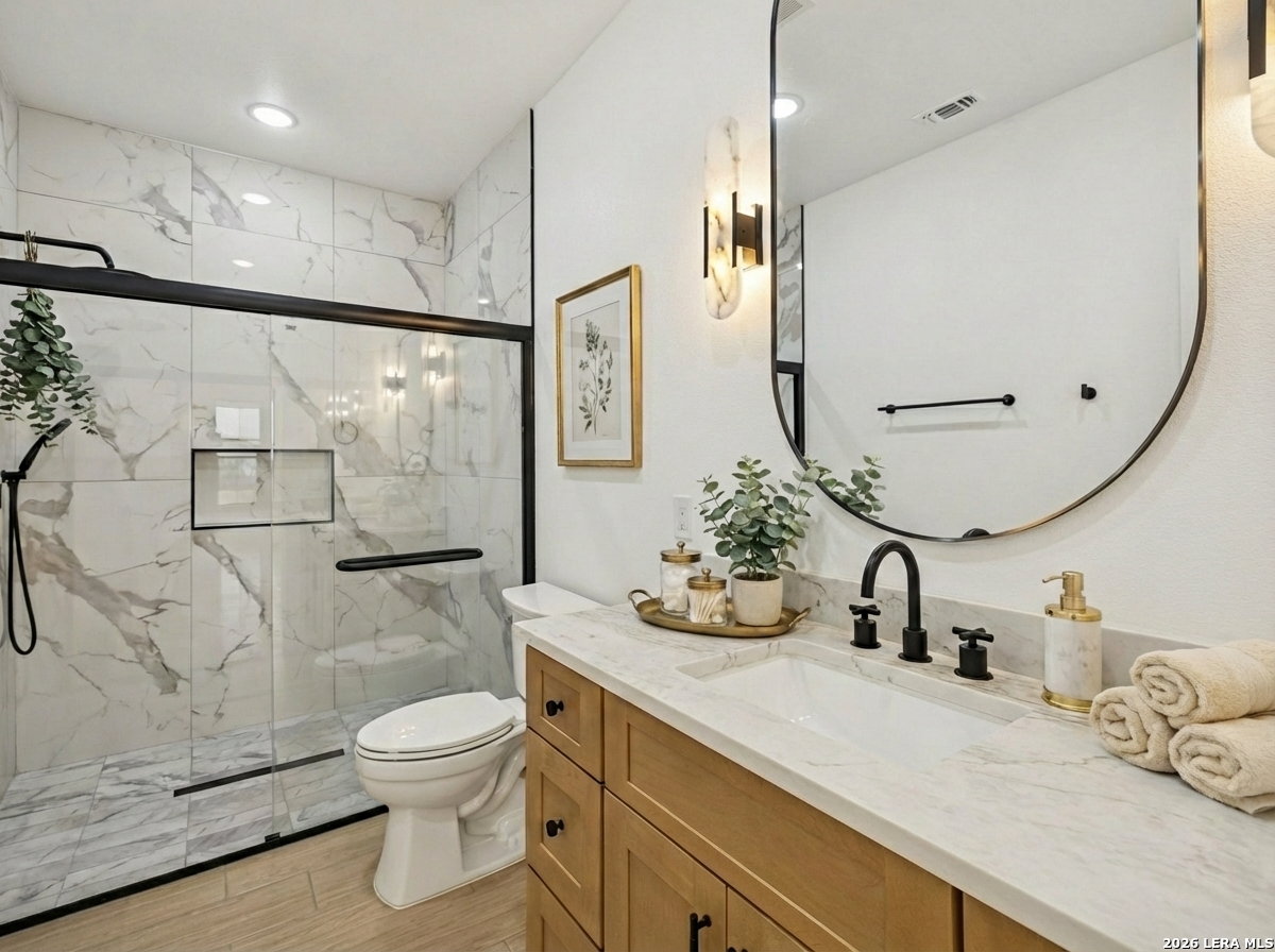 191 Hidden Ranch Court Floresville, TX 78114 - Photo 24 of 38 a bathroom with a granite countertop sink a toilet and shower