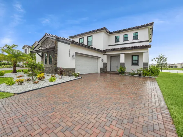 a front view of a house with a yard and a garage