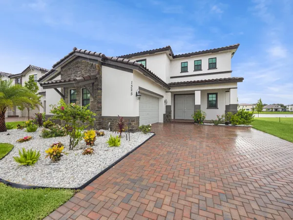 a front view of a house with a yard and potted plants