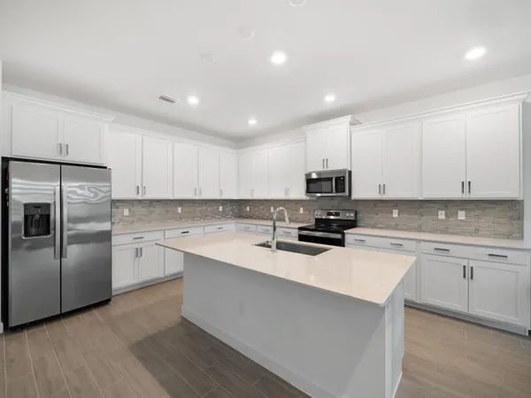 a kitchen with a sink stainless steel appliances and white cabinets