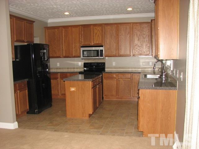 7821 McKee Road Rougemont, NC 27572 - Photo 10 of 25 a kitchen with a refrigerator a stove top oven and a sink
