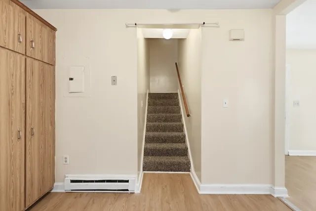 a view of a hallway with wooden floor and entryway