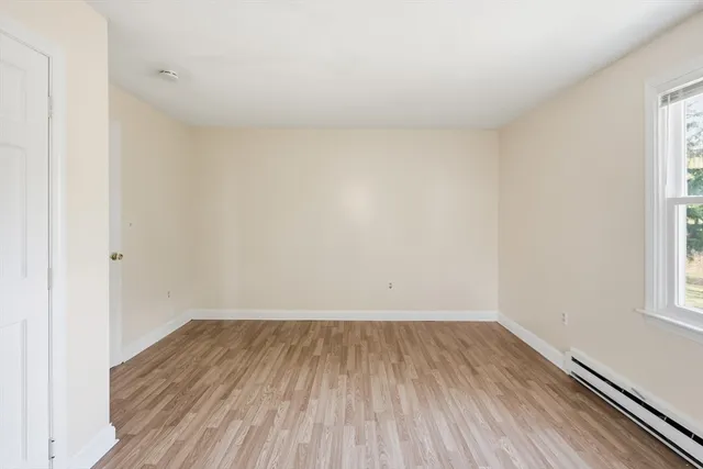 a view of a room with wooden floor and small window