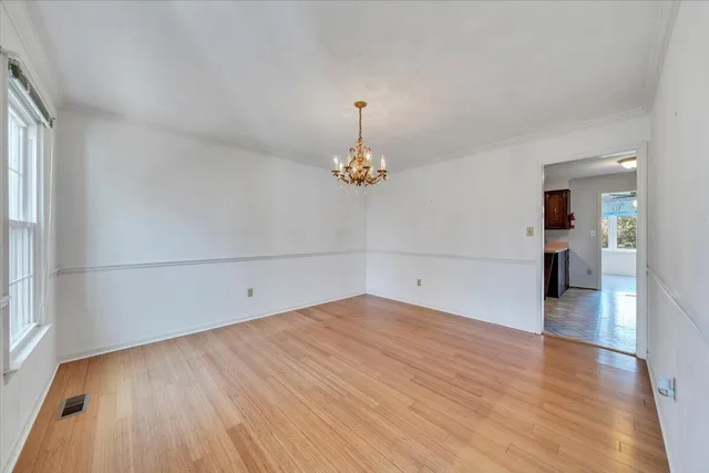 a view of empty room with wooden floor and fireplace