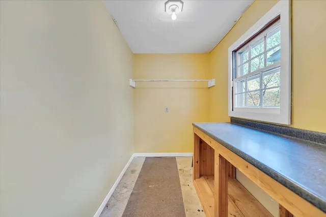 an empty room with windows and ceiling fan