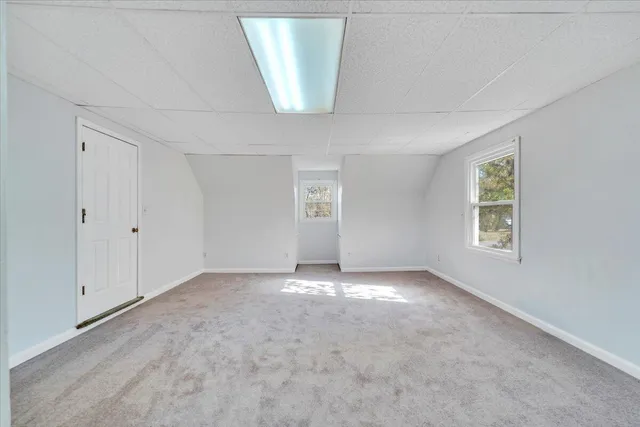 a view of a house with a yard and a large tree