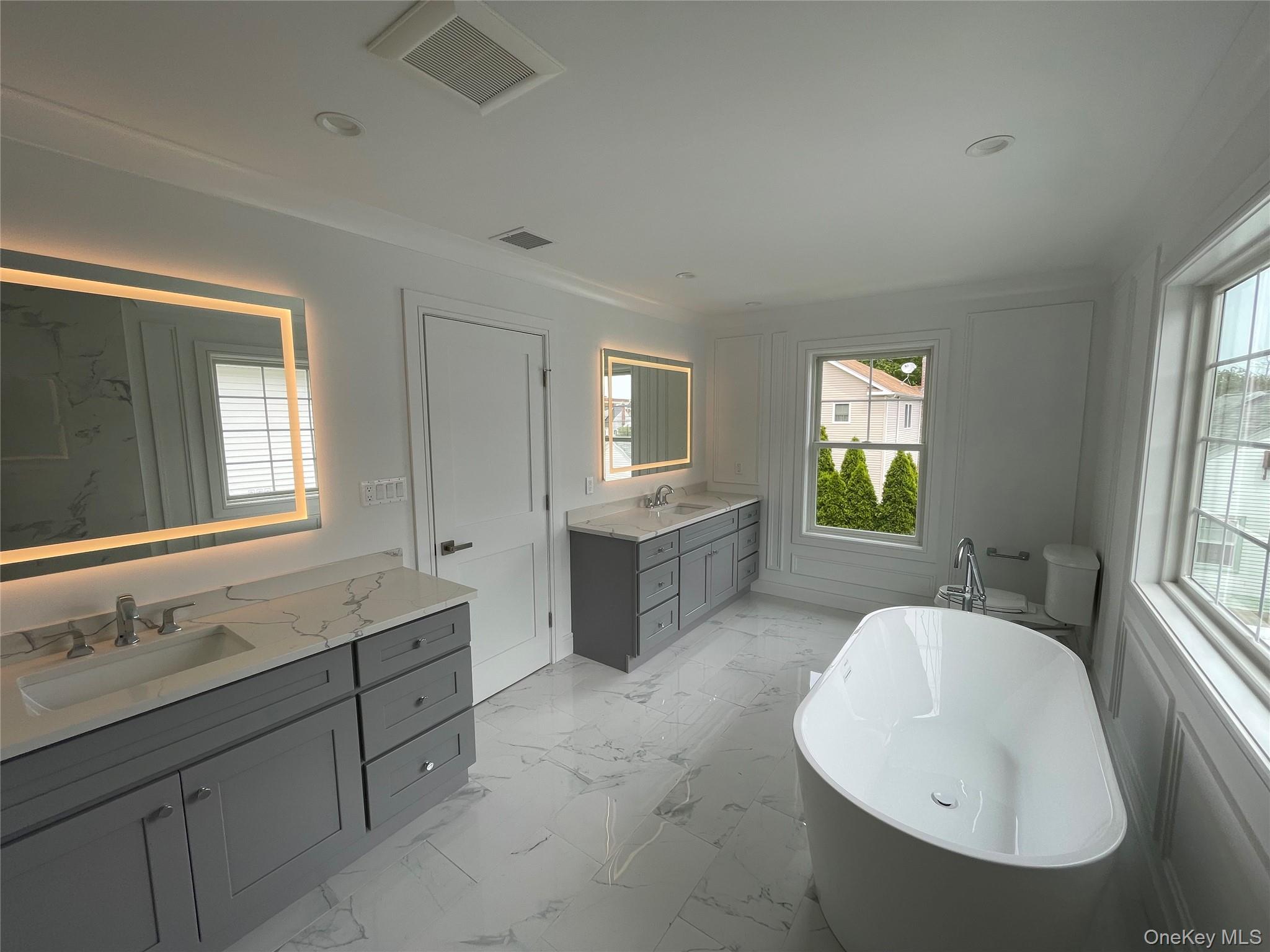 477 Andrews Road, Unit LOT A Mineola, NY 11501 - Photo 14 of 21 a spacious bathroom with a double vanity sink and a mirror