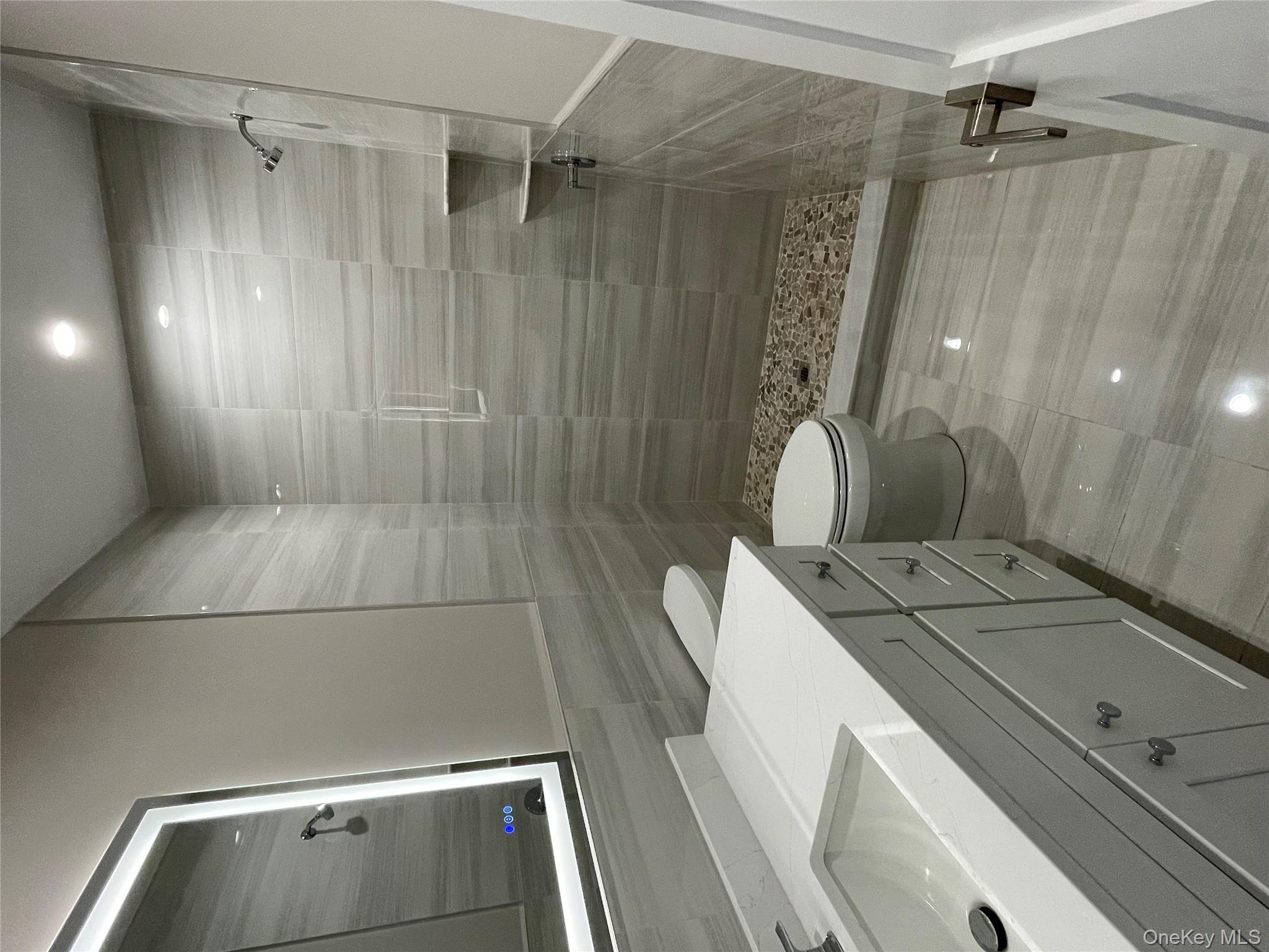 477 Andrews Road, Unit LOT A Mineola, NY 11501 - Photo 16 of 21 a bathroom with a sink a toilet and shower