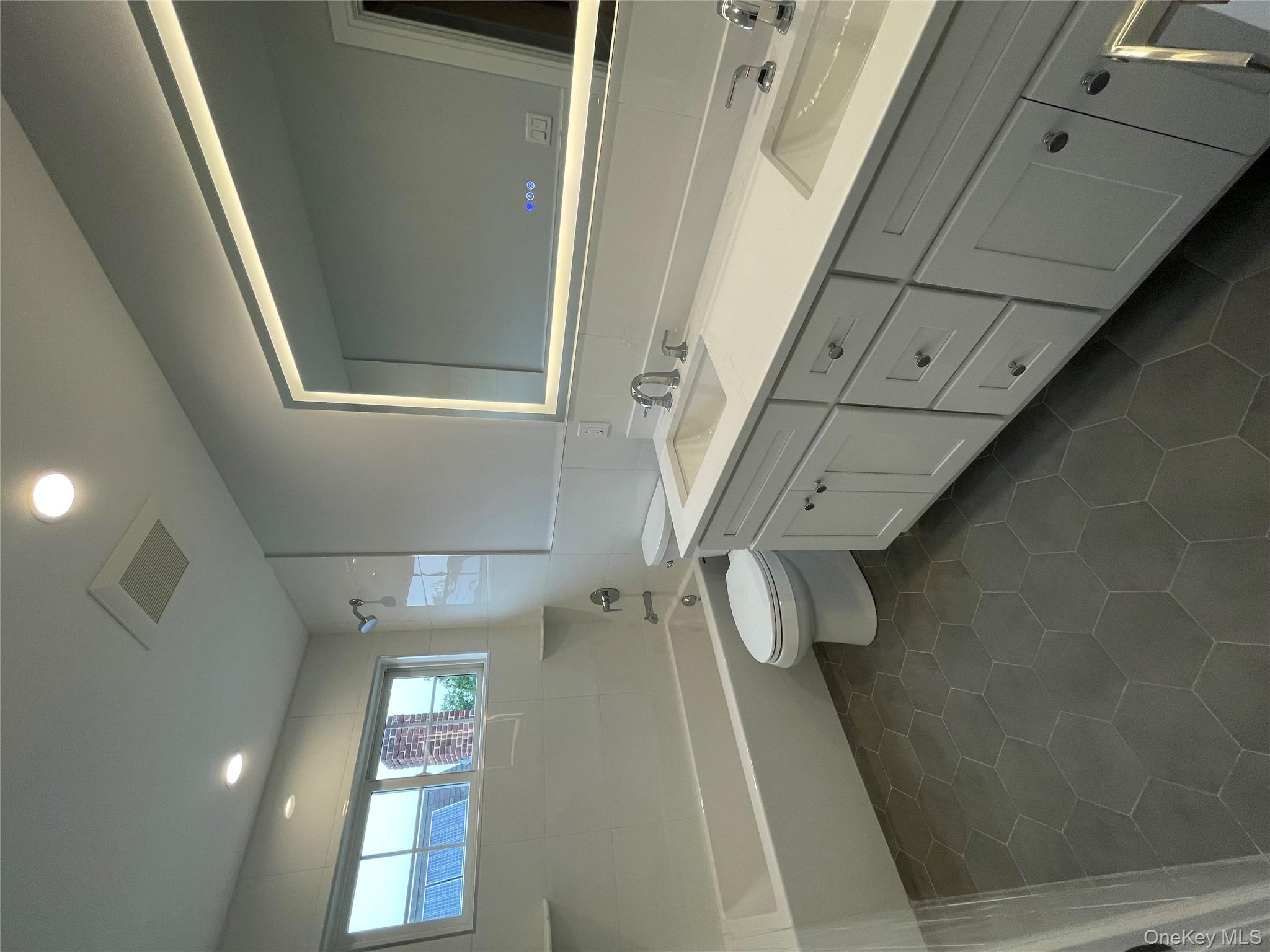 477 Andrews Road, Unit LOT A Mineola, NY 11501 - Photo 18 of 21 a spacious bathroom with a double vanity sink toilet and a tub