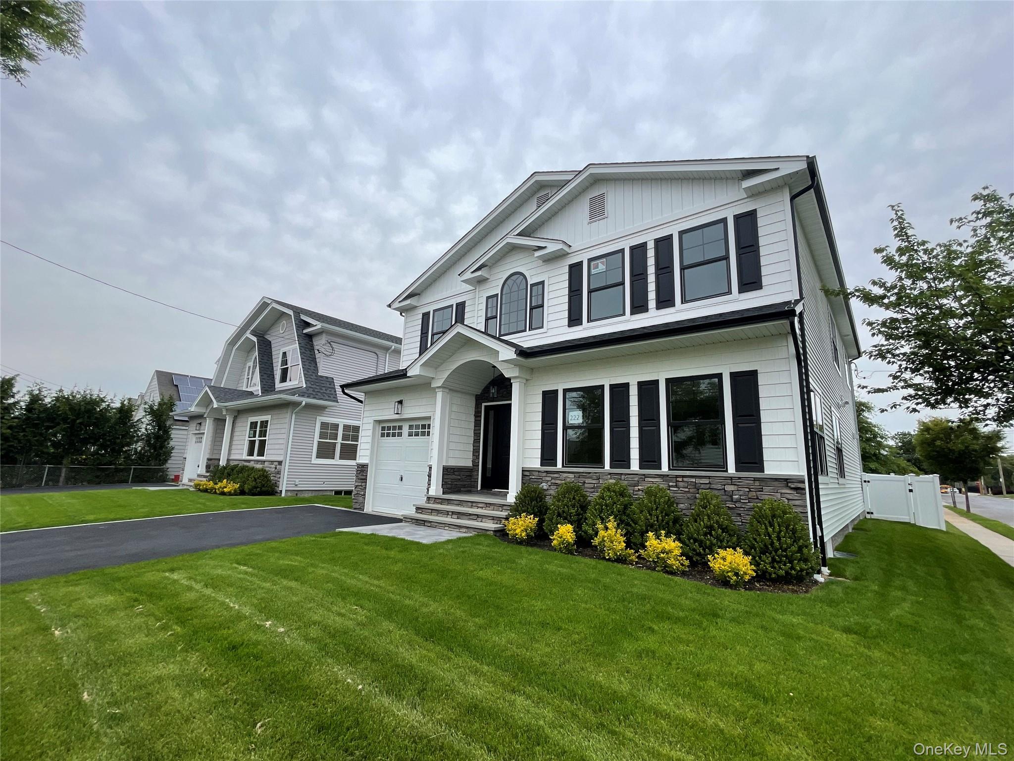 477 Andrews Road, Unit LOT A Mineola, NY 11501 - Photo 3 of 21 a front view of a house with a yard