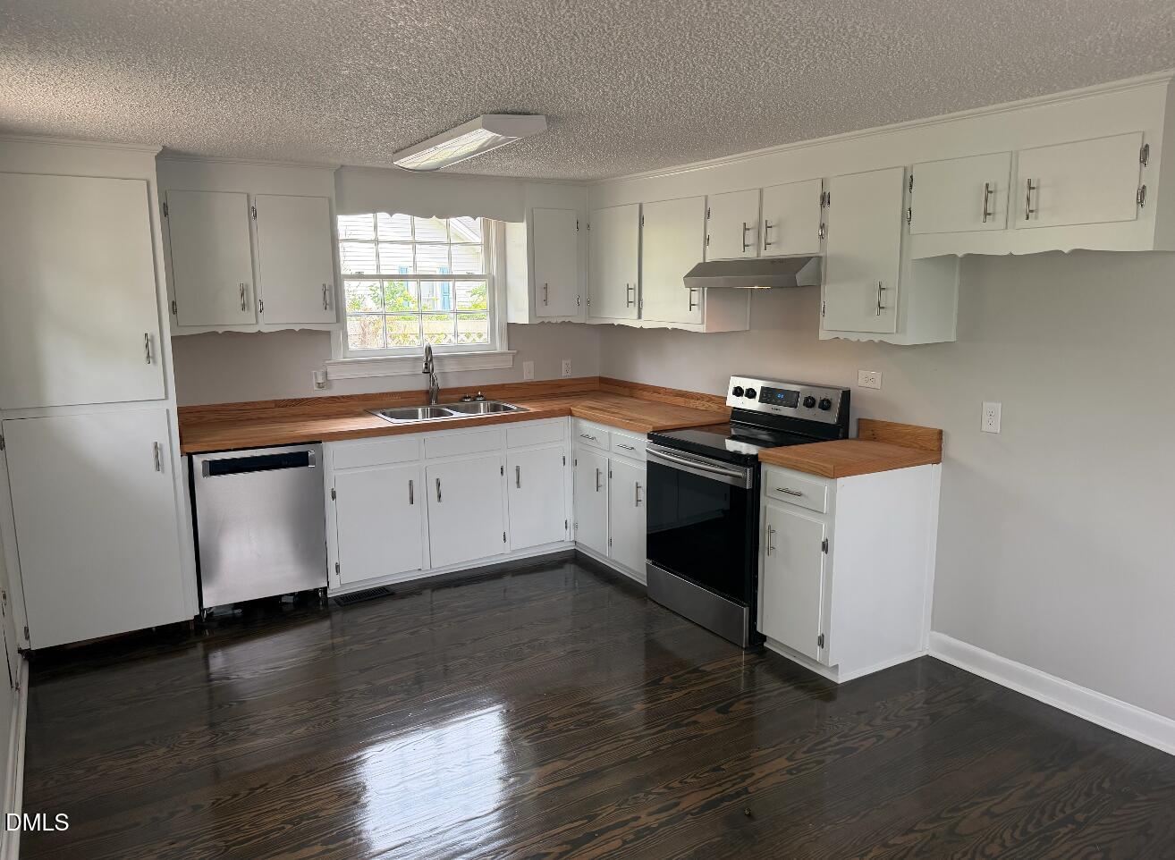 702 West Main Street Benson, NC 27504 - Photo 13 of 16 a kitchen with stainless steel appliances granite countertop a sink stove and wooden floor
