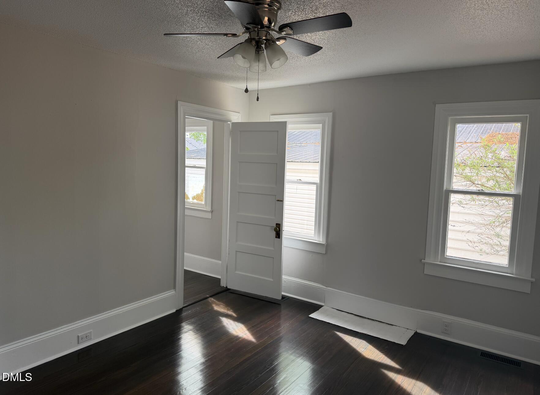 702 West Main Street Benson, NC 27504 - Photo 7 of 16 wooden floor in an empty room with a window