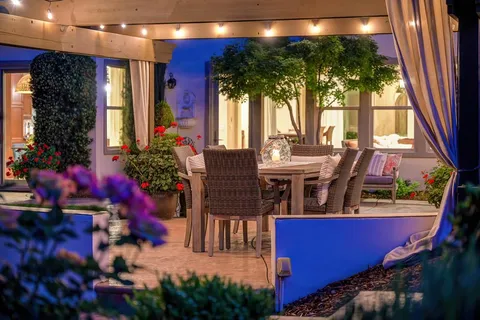 a kitchen with stainless steel appliances kitchen island granite countertop a table chairs and a refrigerator