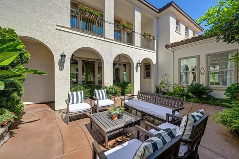 a dining room with furniture potted plants and wooden floor