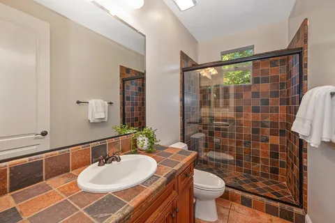 a bathroom with a sink a toilet and a mirror