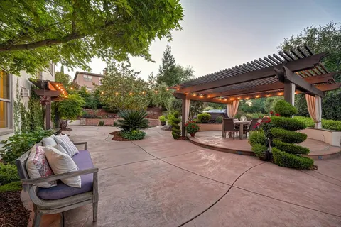 a view of a garden with a bench in front of the house