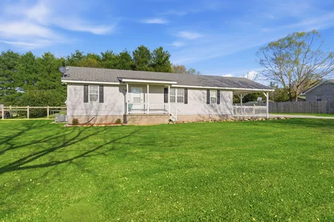 a front view of house with yard and green space