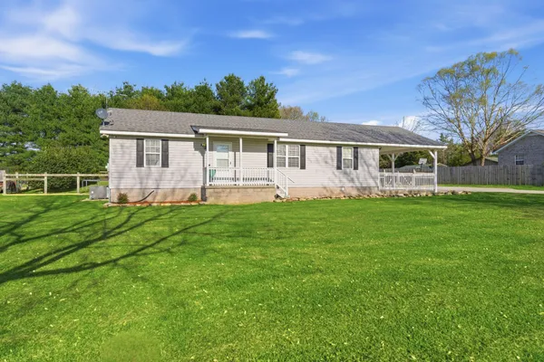 a front view of house with yard and green space