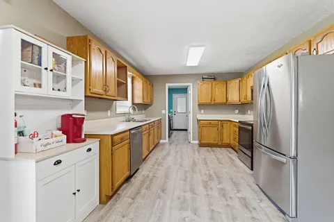 a kitchen with kitchen island a sink wooden floor and stainless steel appliances