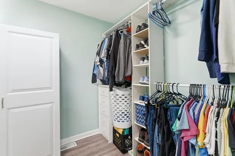 a view of walk in closet with clothes and shoes