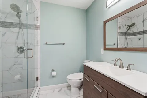 a bathroom with a sink a toilet and shower