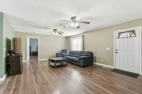 a living room with furniture and a wooden floor