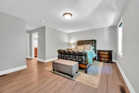 a bedroom with furniture and wooden floor