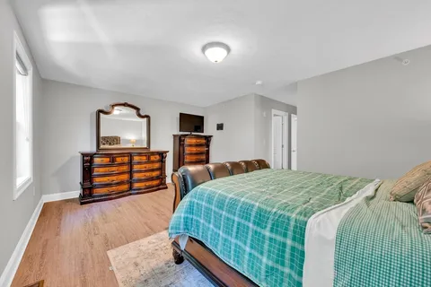 a bedroom with a bed and wooden floor