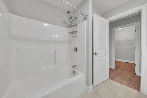 a bathroom with a shower a bathtub and a shower