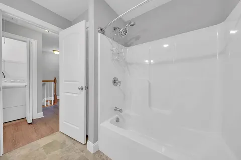 a bathroom with a bathtub shower and a sink