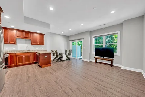 a living room with furniture a flat screen tv and floor to ceiling window