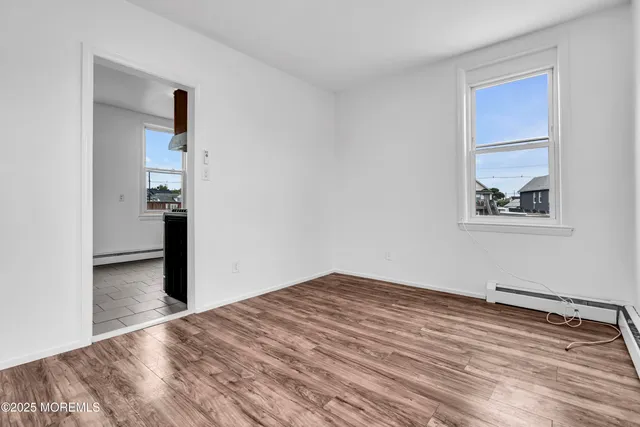a view of empty room with wooden floor
