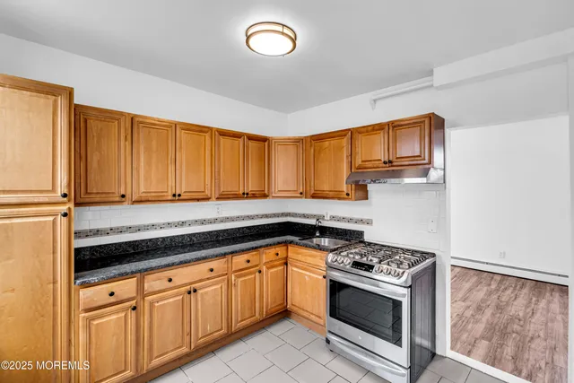 a kitchen with stainless steel appliances granite countertop a stove a sink and a microwave