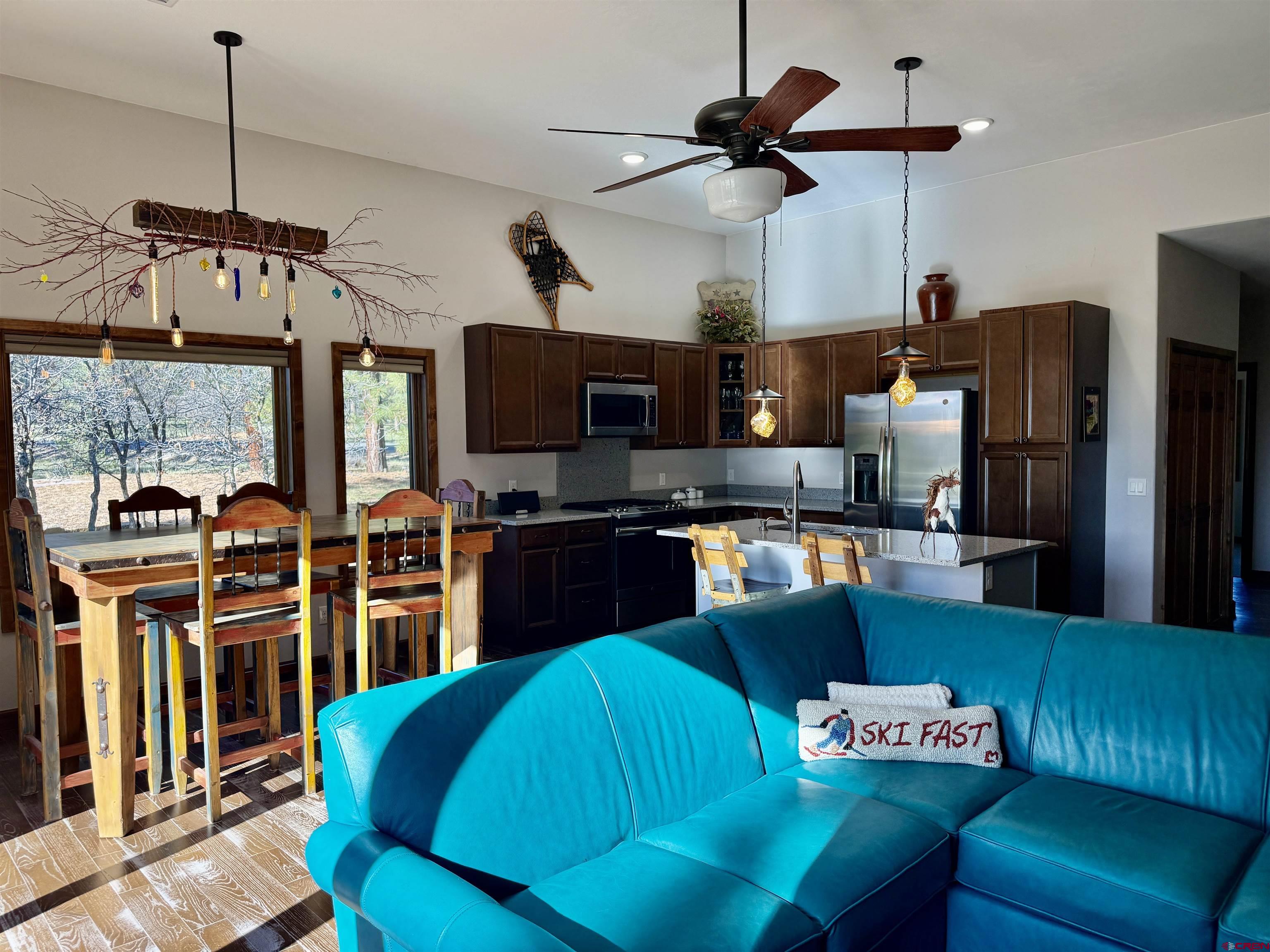 592 South Badger Trail Ridgway, CO 81432 - Photo 8 of 29 a kitchen with stainless steel appliances kitchen island granite countertop a refrigerator a sink a stove and a dining table