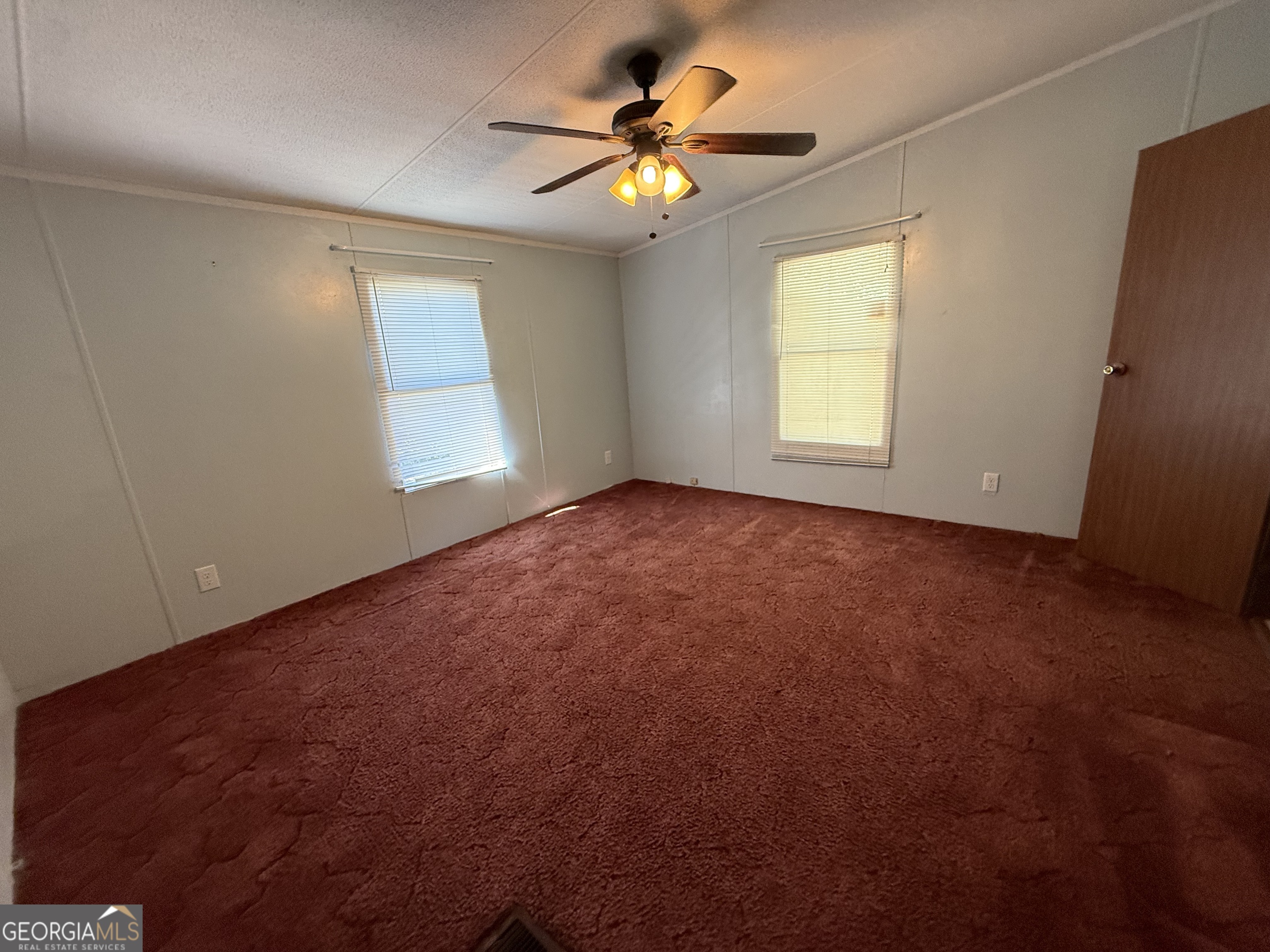 802 Ash Branch Road Pembroke, GA 31321 - Photo 21 of 27 an empty room with windows and chandelier fan