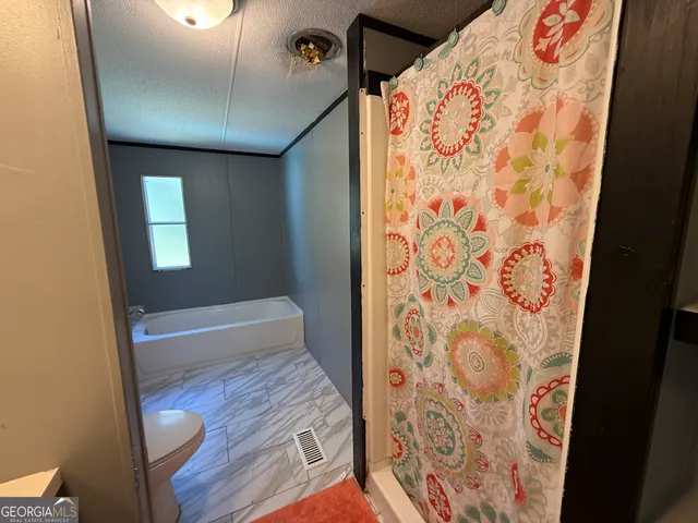 a bathroom with a bathtub and shower curtain