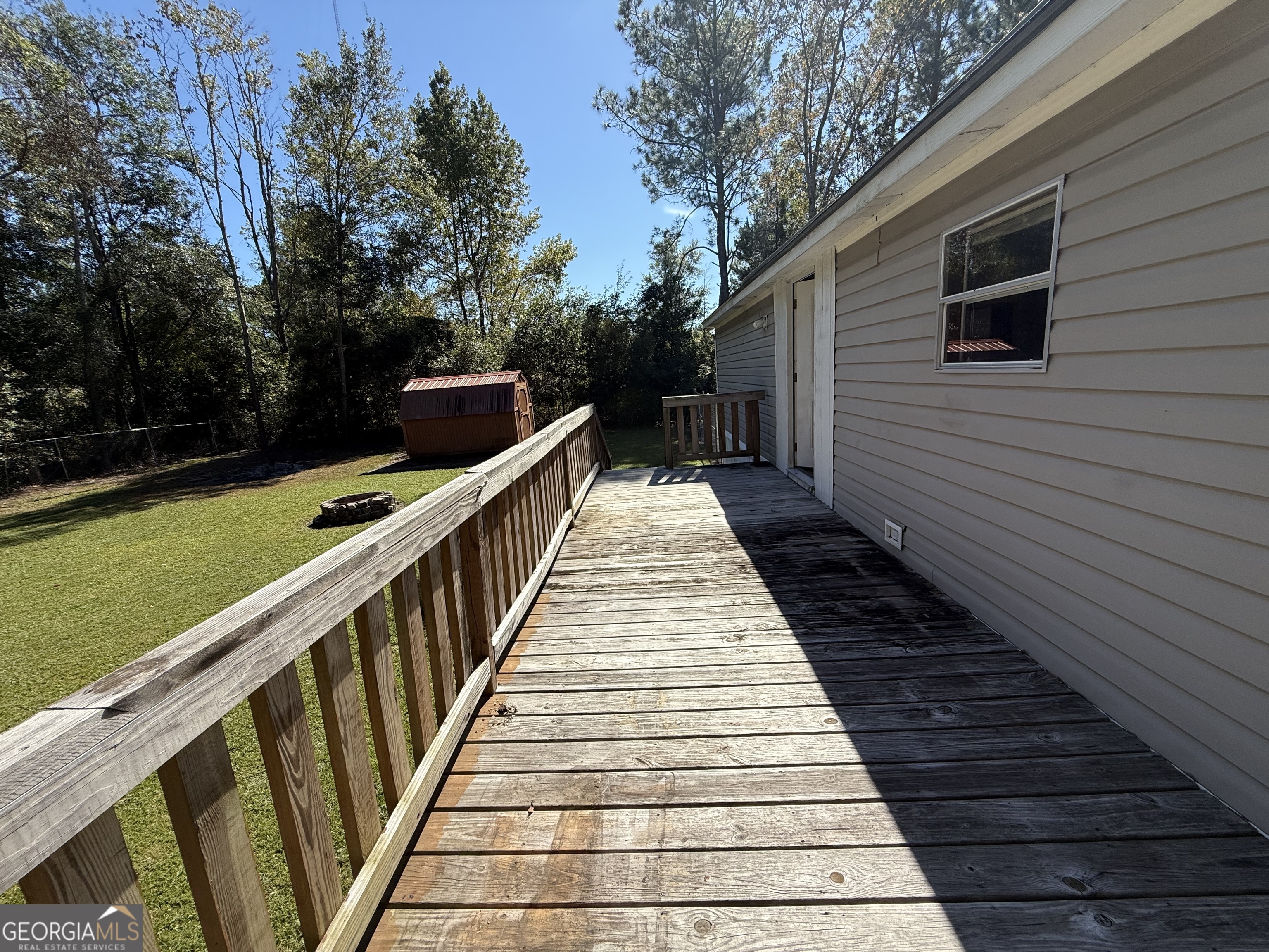 802 Ash Branch Road Pembroke, GA 31321 - Photo 9 of 27 a balcony with wooden floor and large trees