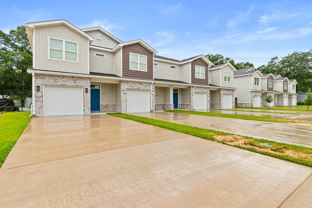 a view of a white house with a swimming pool and a yard